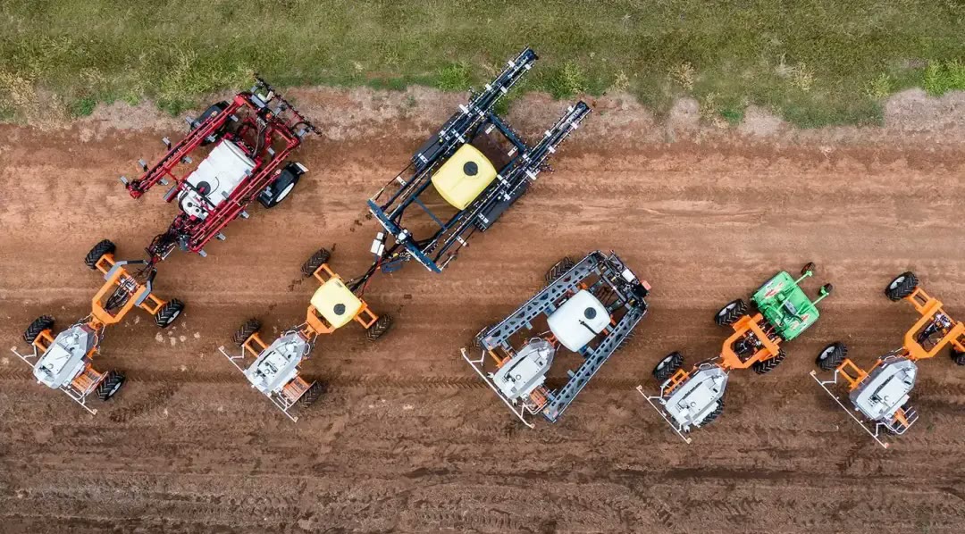 SwarmFarm robots lined up on red soil, seen from above